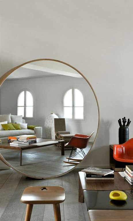 Большое круглое зеркало на полу гостиной фото