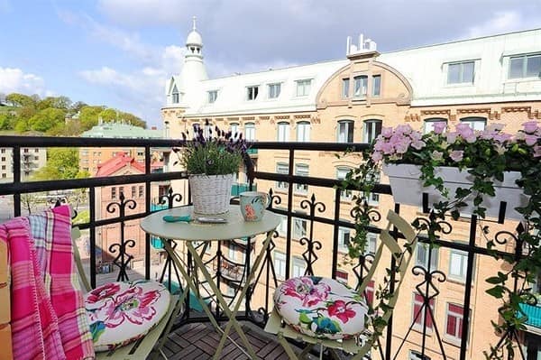 Подвесные горшки с цветами в месте для отдыха на балконе