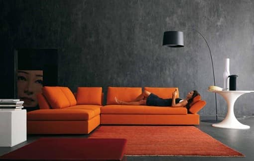 Яркий оранжевый диван и темные стены