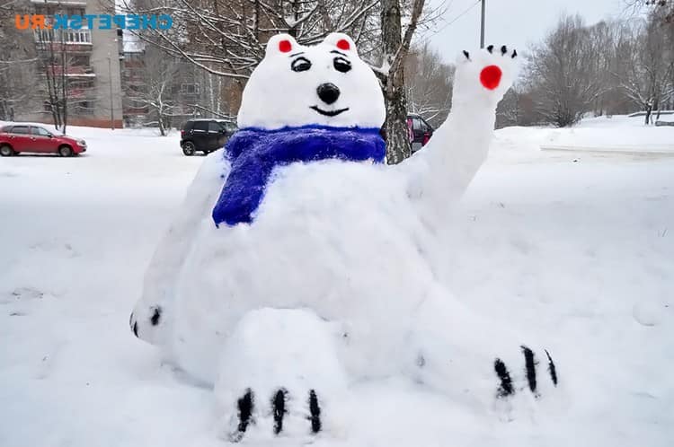Медведь с поднятой лапой из снега 