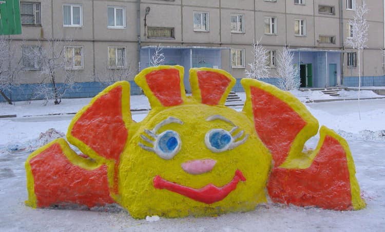 Позитивное солнышко, сделанное из снега и раскрашенное красками
