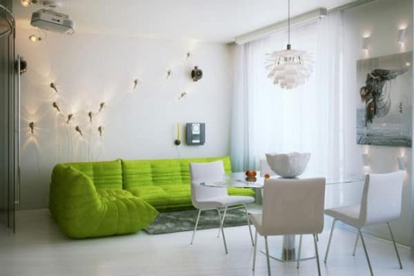Зеленый диван - единственная яркая деталь белой гостиной