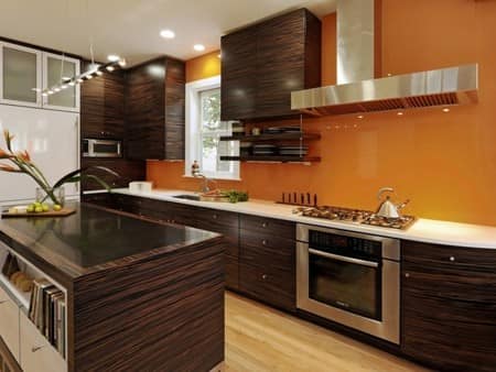 Оранжевые обои и коричневая мебель на кухне