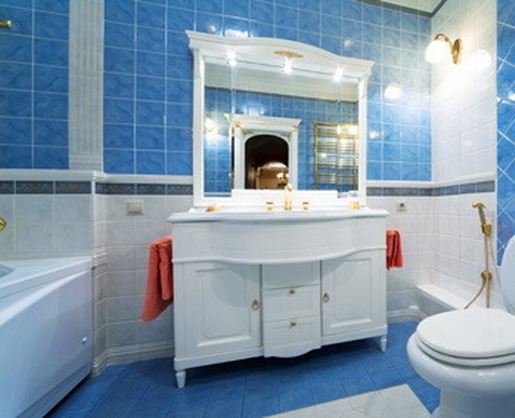Яркие полотенца делают холодный бело-голубой интерьер ванной комнаты более уютным