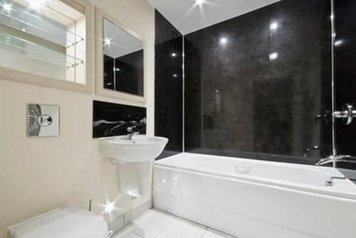 Яркое освещение украшает интерьер черно белой ванной