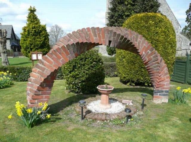 Витая кирпичная арка вместе садовой статуи