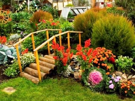 Кантри стиль сада: деревянный мостик и декоративный пруд или клумбы с цветами